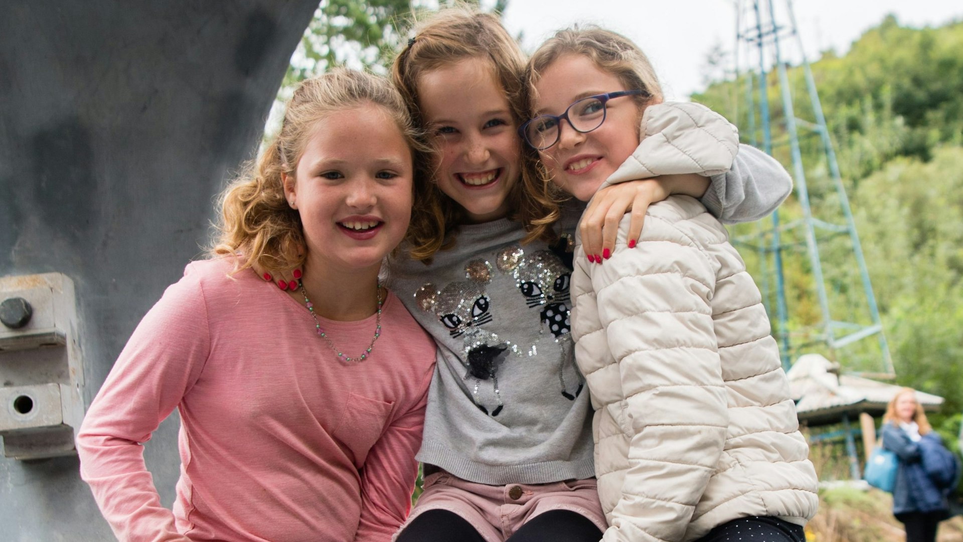 Children hugging looking through a wind turbine hub